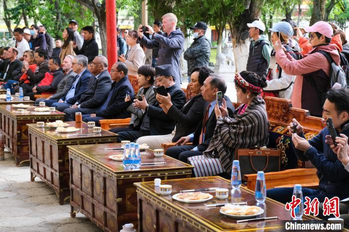 5月19日，中外嘉賓在羅布林卡和游客一起觀看藏戲?！〗w波 攝