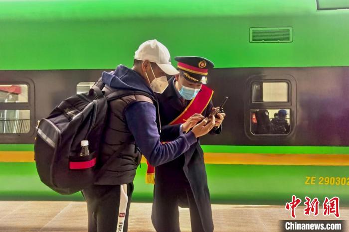 圖為日喀則火車站工作人員服務乘客?！《飞降?攝