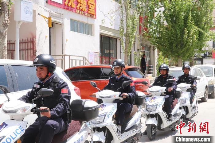 民警騎著電瓶車在轄區(qū)巡邏走訪。　黃創(chuàng)偉 攝