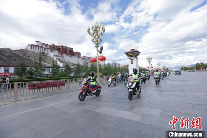 圖為比賽選手途經(jīng)布達拉宮?！∮文恋厍蚬﹫D