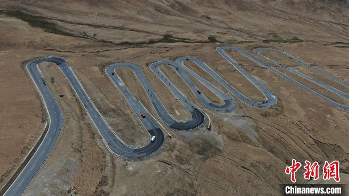 圖為騎手前往珠峰大本營途經(jīng)108道拐?！∮文恋厍蚬﹫D