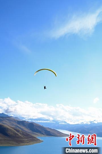 圖為在羊卓雍錯(cuò)，游客體驗(yàn)高空滑翔?！≮w朗 攝