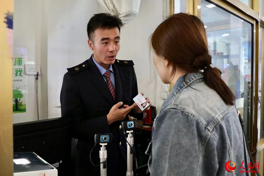 車站工作人員向旅客解答疑問。人民網(wǎng)記者 次仁羅布攝