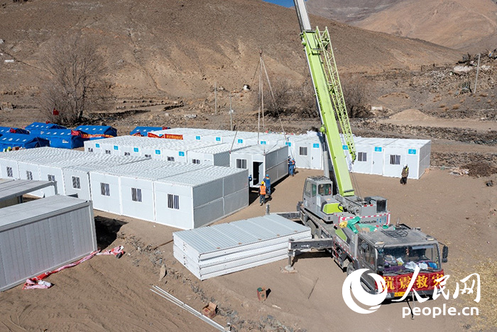 1月9日，在日喀則市定日縣長所鄉(xiāng)古榮村安置點，救援人員和施工人員合力抓緊搭建移動板房，確保受災群眾溫暖過冬。人民網(wǎng)記者 翁奇羽攝