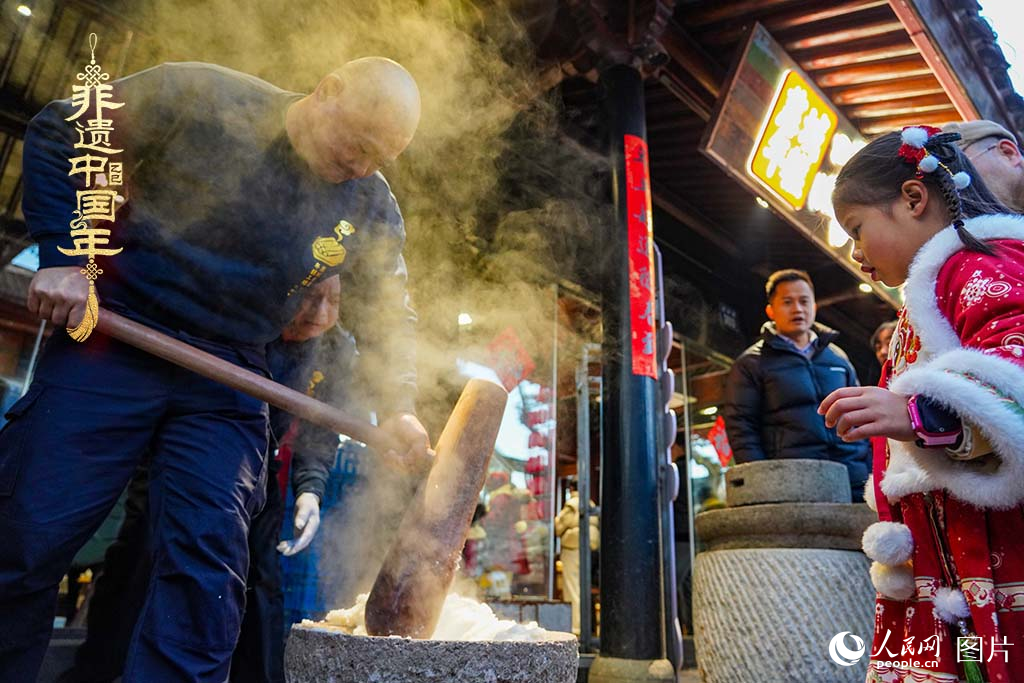 2025年1月29日，浙江省寧波市江北區(qū)慈城古縣城，市民和游客觀看搗年糕。人民網(wǎng) 章勇濤攝
