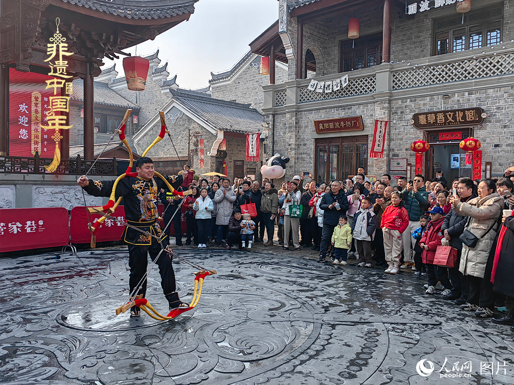 2025年1月29日，湖北襄陽市管家巷，老北京天橋大刀張舉大刀拉硬弓第五代傳承人現(xiàn)場(chǎng)表演，一次拉開6張弓，引來游客喝彩。人民網(wǎng)記者 郭婷婷攝