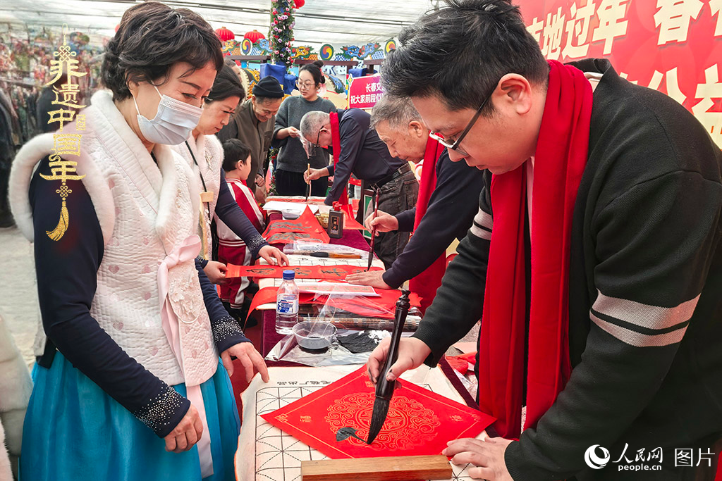 新春佳節(jié)之際，長(zhǎng)春農(nóng)博園冬季展會(huì)火熱進(jìn)行，展廳內(nèi)，書法家現(xiàn)場(chǎng)書寫“?！弊郑忻裼慰图娂娚锨坝航印案！薄Ｈ嗣窬W(wǎng)記者 王海躍攝