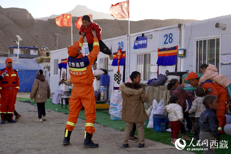 熱木青村安置點(diǎn)，消防員們同孩子們嬉戲玩耍。人民網(wǎng)記者 次仁羅布攝